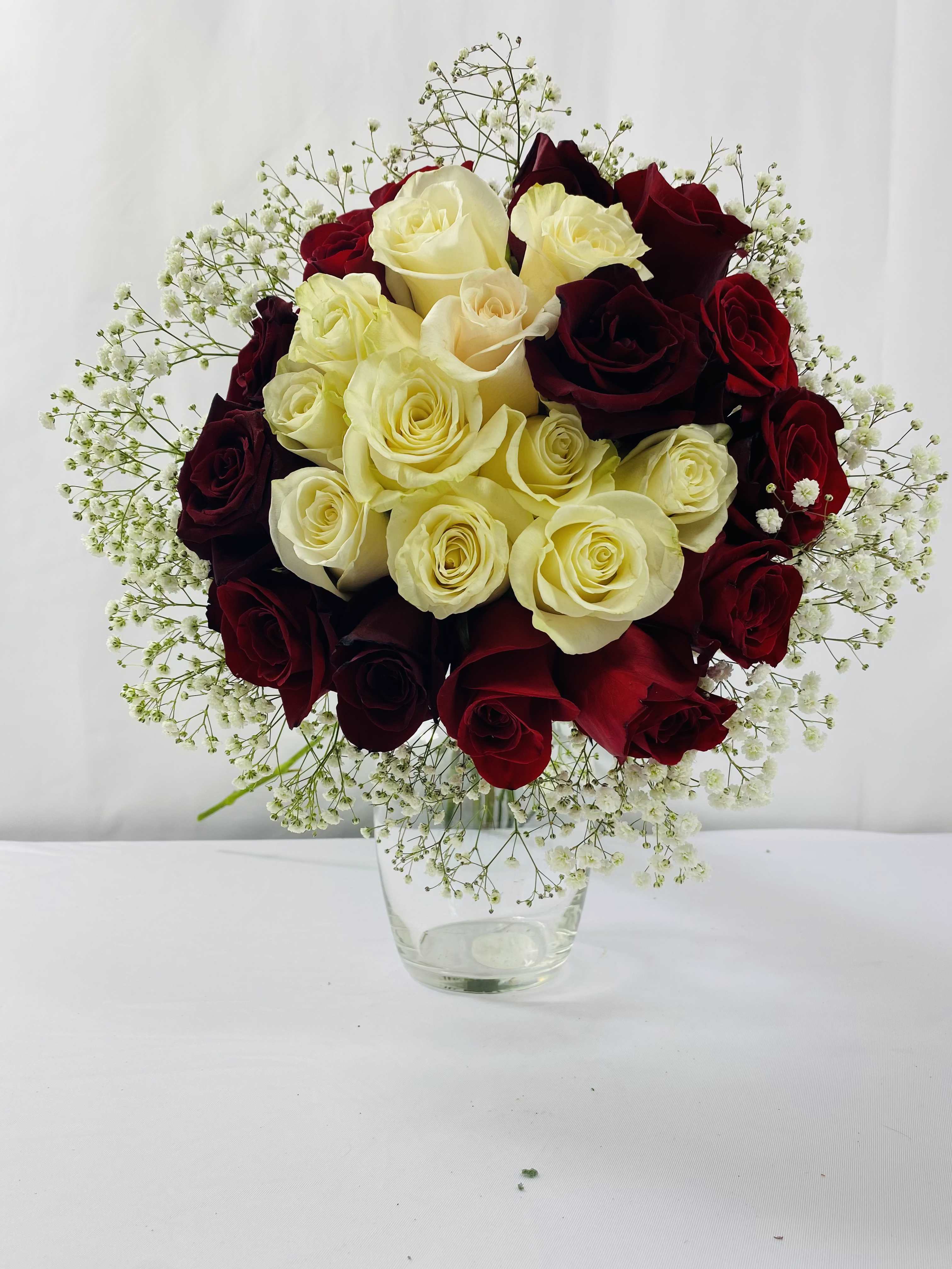 Bouquet of red and cream roses in a clear glass vase