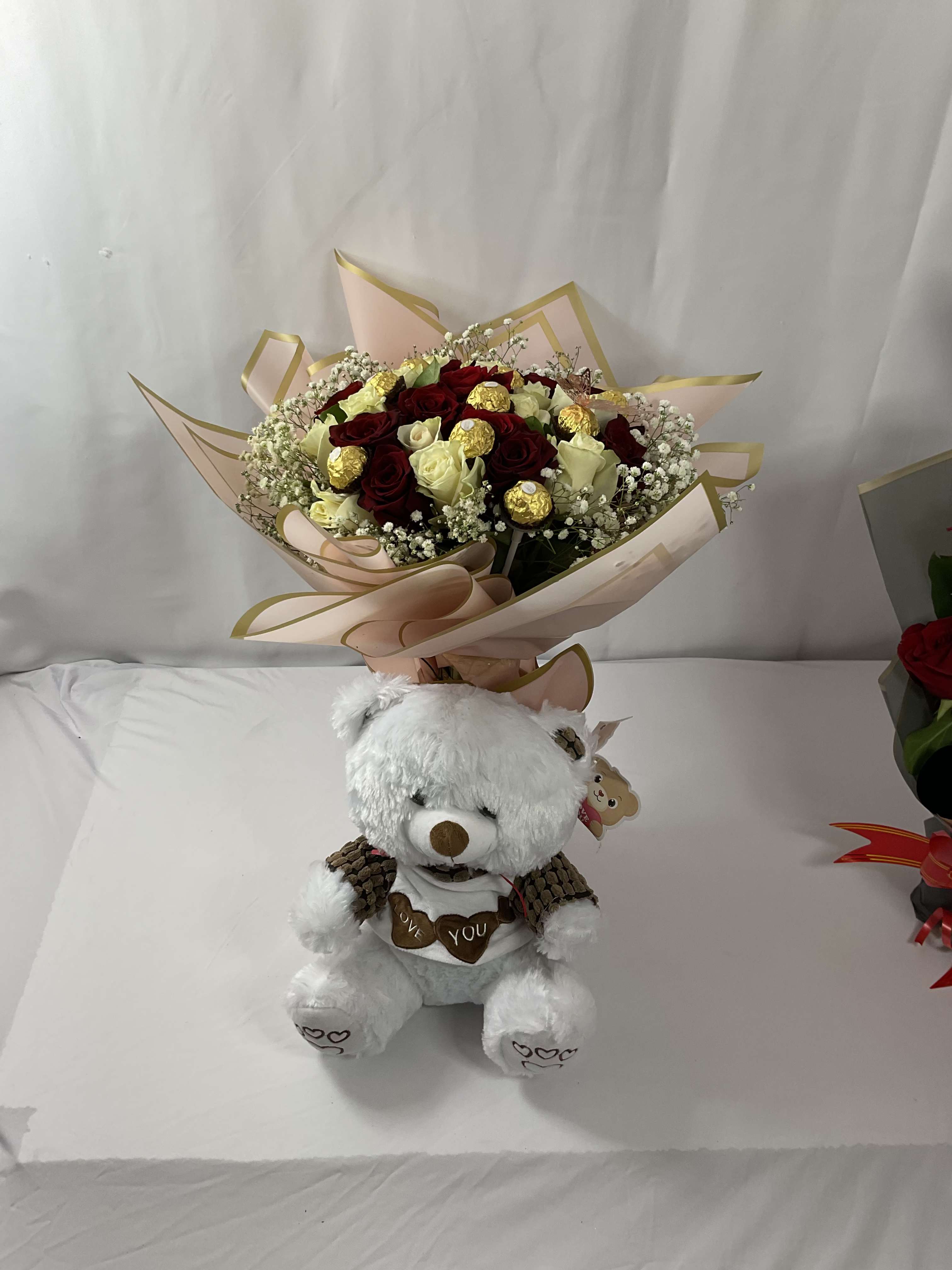 Bouquet of red and white roses with a teddy bear