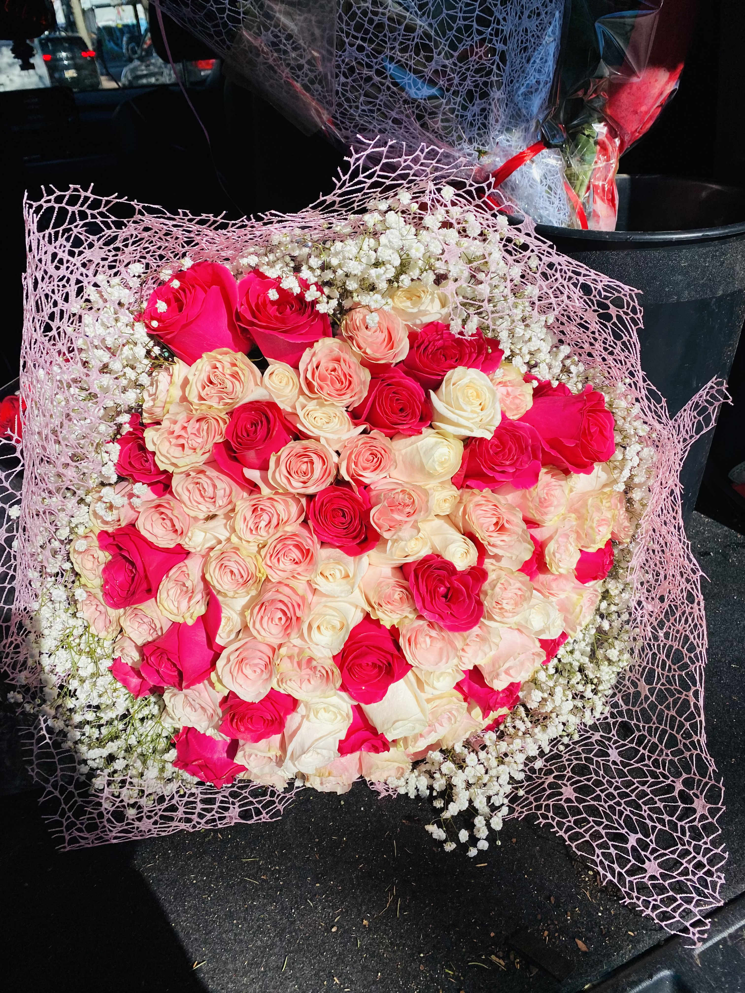 Bouquet of pink and cream roses wrapped in pink mesh