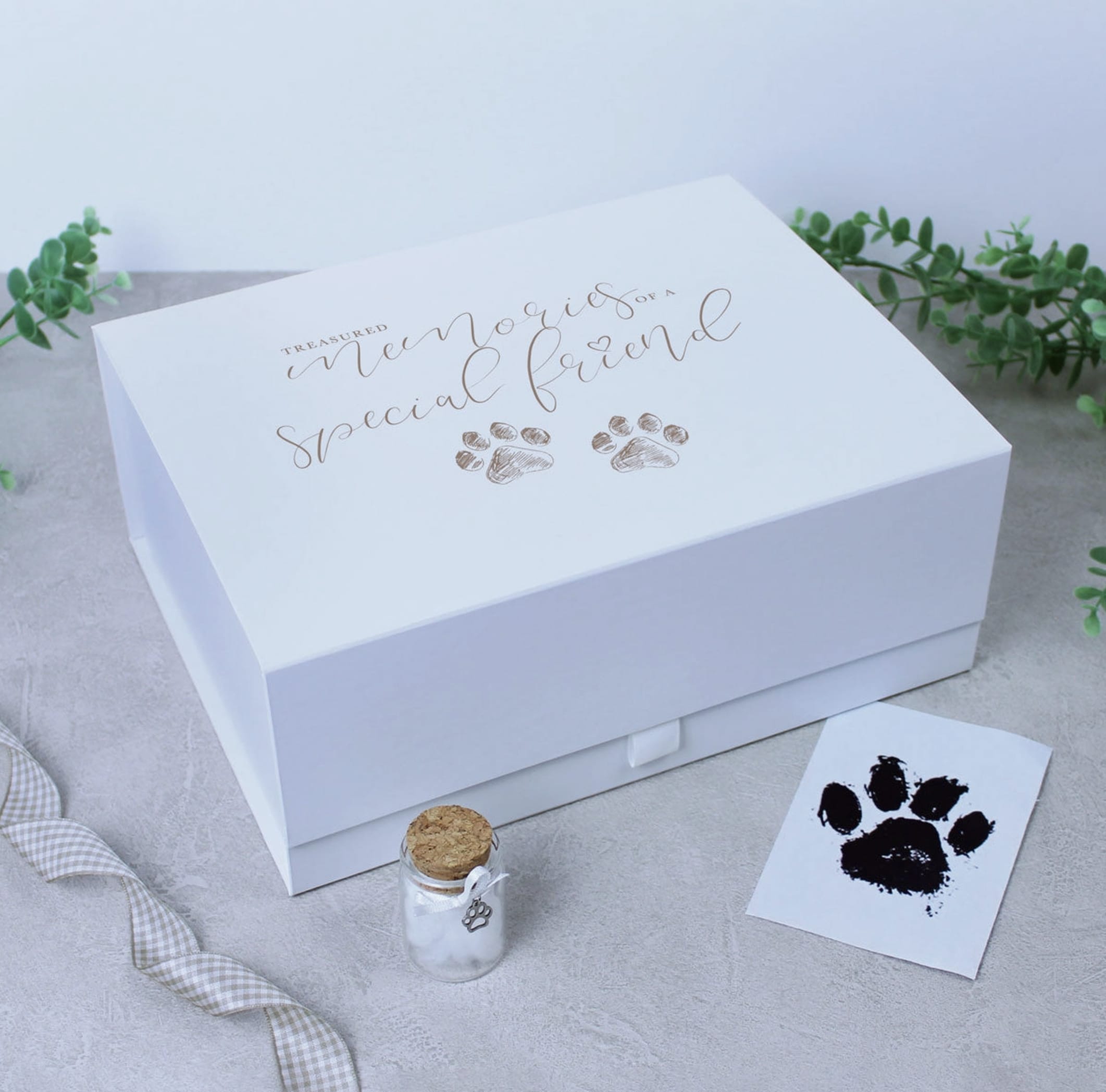 White memorial keepsake box with paw print design and a small glass vial