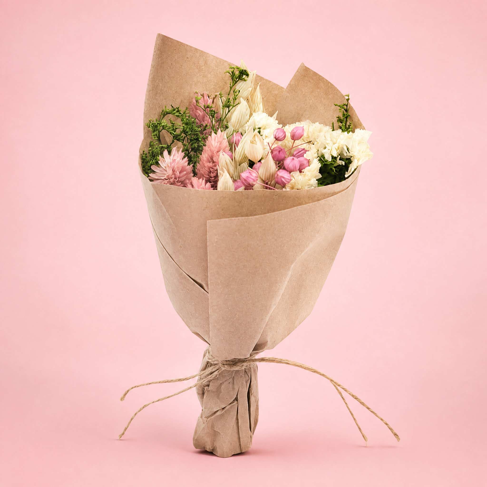 Bouquet of pink and white flowers wrapped in brown paper