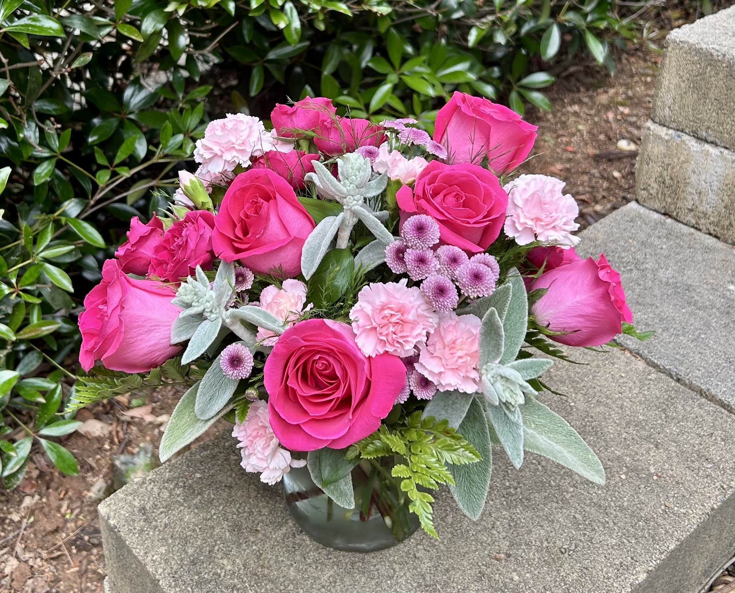 Sweetheart Whisper - Charming and compact, featuring bright pink roses nestled among soft carnations and fresh greenery—perfect for heartfelt moments.