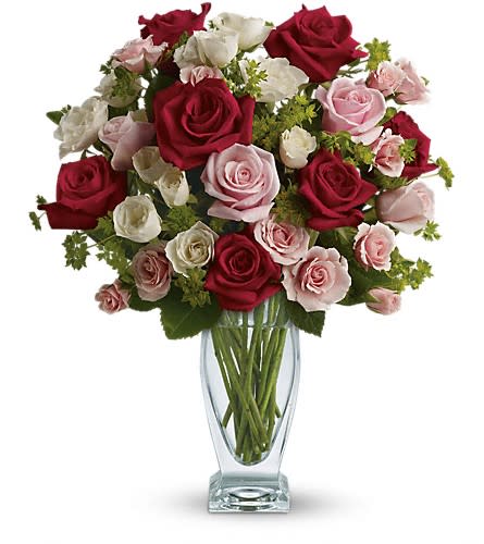 Bouquet of red, pink, and white roses in a clear glass vase