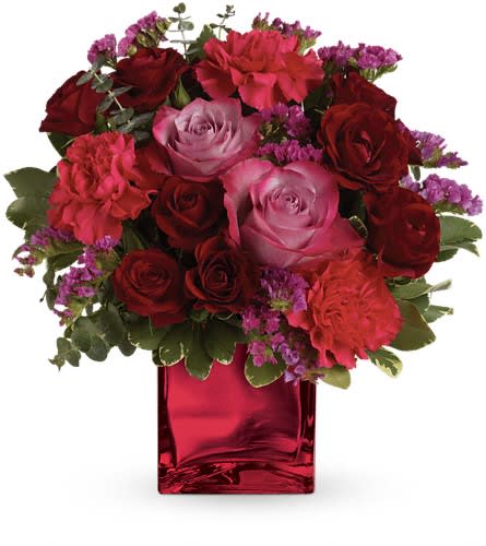 Bouquet of red and pink roses in a red glass vase