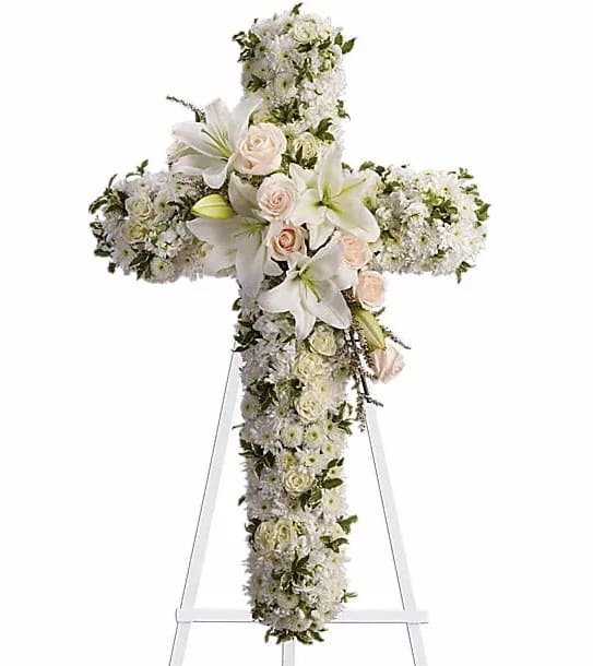 Divine Light - Your message of hope for eternal serenity is delivered ever so elegantly in this graceful cross. Your sincerity will be acknowledged by all who are present. CrÃ¨me roses white spray roses oriental lilies stock leptosporum cushion and button spray chrysanthemums create a cross that is a beautiful way to honor a loved one.