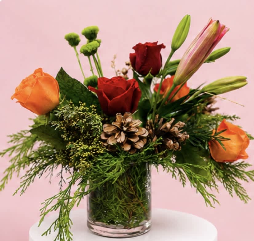 Bouquet of red and orange roses with lilies in a glass vase