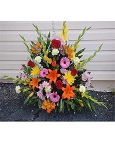 Colorful standing floral spray with lilies, roses, and daisies