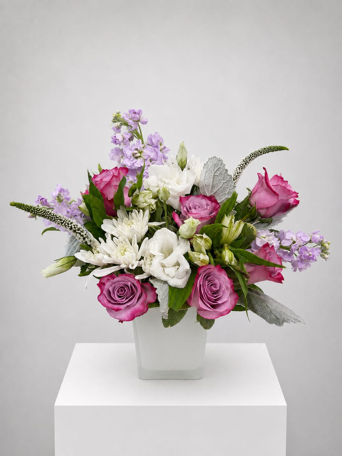 Pink and white mixed flower arrangement in a square white vase