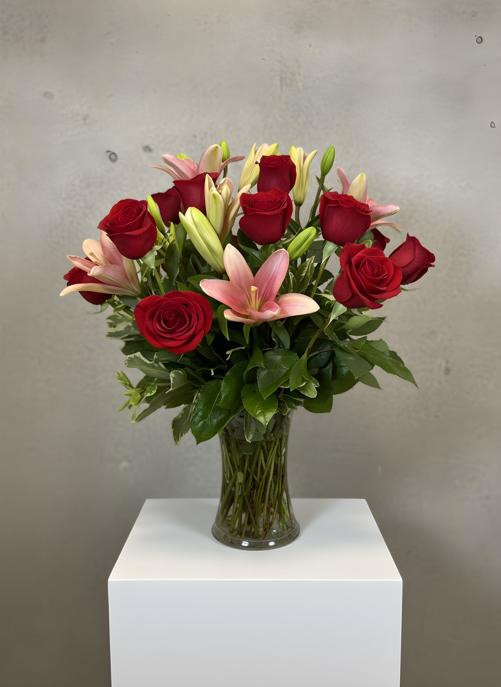 Ever After - Celebrate life's most meaningful moments with Ever After, a timeless floral arrangement featuring premium long-stem red roses and fragrant pink lilies beautifully designed in a clear glass vase. Rich red roses symbolize enduring love and romance, while elegant pink lilies add softness, grace, and beauty, creating a stunning bouquet perfect for anniversaries, birthdays, Valentine's Day, weddings, or simply letting someone know they're loved.  Handcrafted by the expert designers at All Occasions Florist, Ever After is arranged using the freshest seasonal flowers available to ensure exceptional quality, beauty, and longevity. Whether you're sending flowers to a home, office, hospital, or special event, this classic rose and lily bouquet makes a lasting impression.  We proudly offer same-day flower delivery throughout Dallas, Richardson, Plano, Garland, University Park, Highland Park, Irving, Farmers Branch, and surrounding DFW communities when ordered by our daily cutoff time.  Container: Clear glass vase.  Because we use only fresh flowers, slight variations in bloom size or shade may occur while maintaining the overall style, color palette, and value of the arrangement. Every bouquet is professionally handcrafted with care to create a beautiful and memorable gift for any occasion.