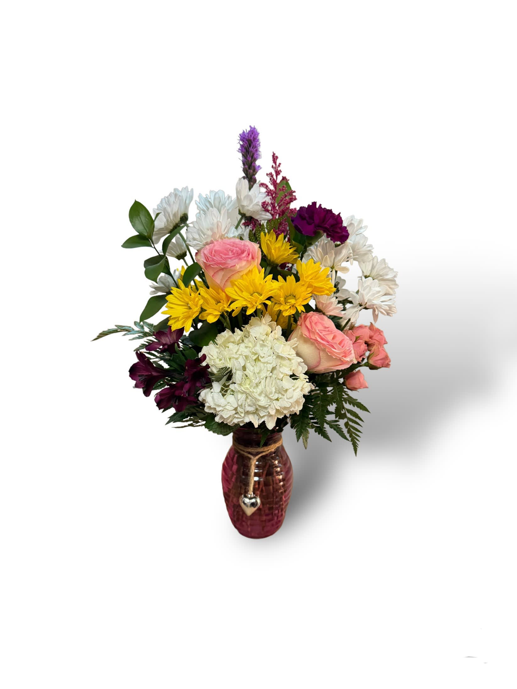 Heart on a string bouquet - You have my heart on a string. This bouquet is filled of bright, vibrant flowers, including roses hydrangea, Liatris daisies overflowed in a jewel tone vase.