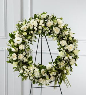 White floral wreath on a black stand