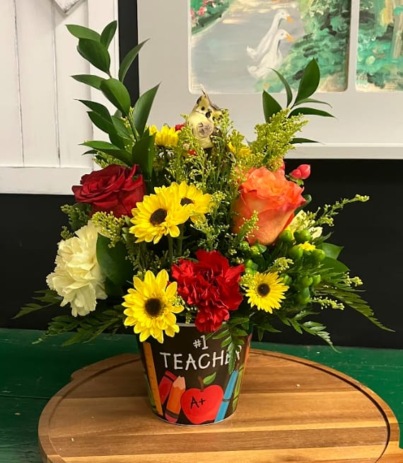 Colorful mixed flower arrangement in a teacher-themed pot