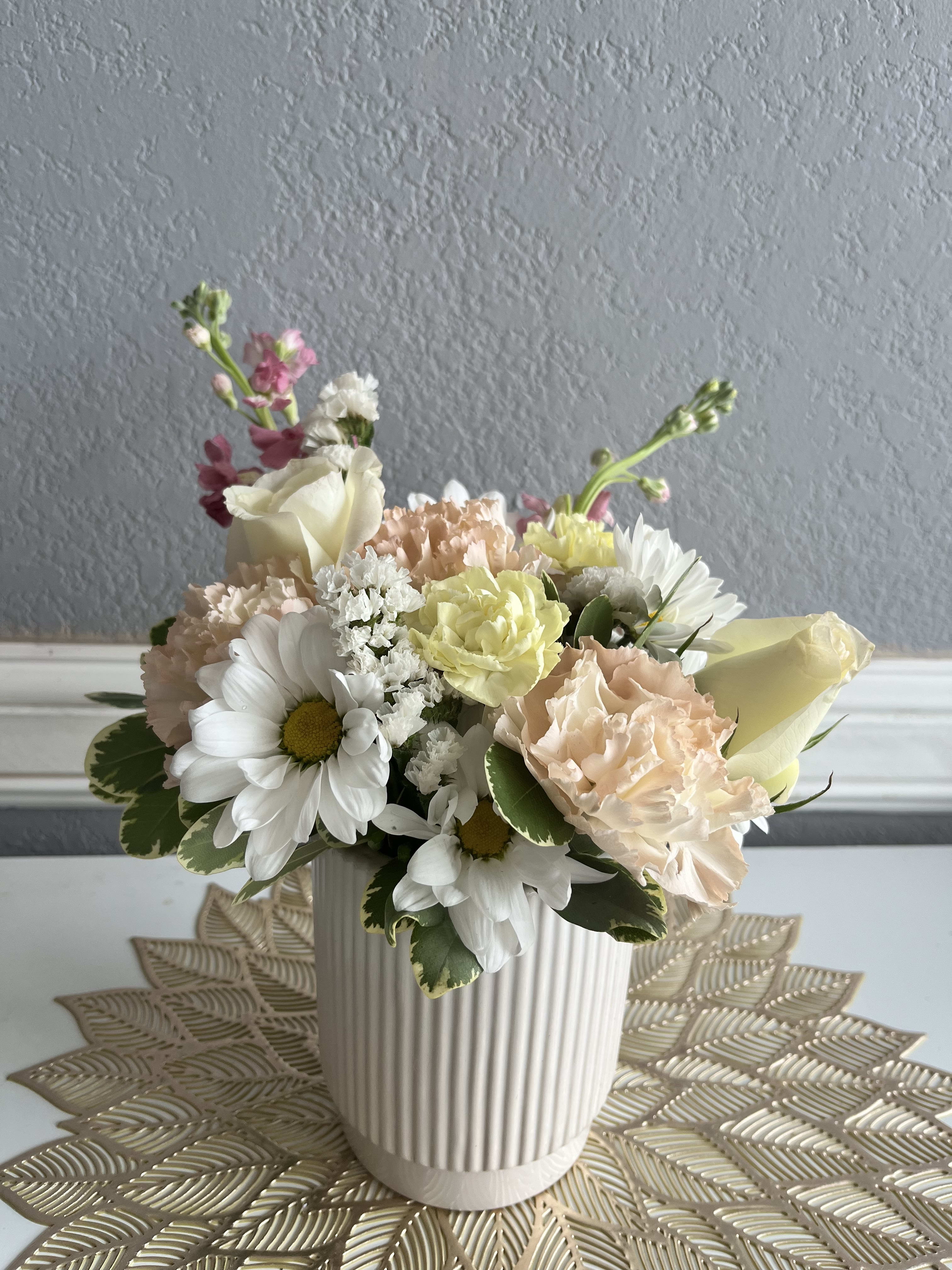 Pastel flower arrangement in a ribbed white vase