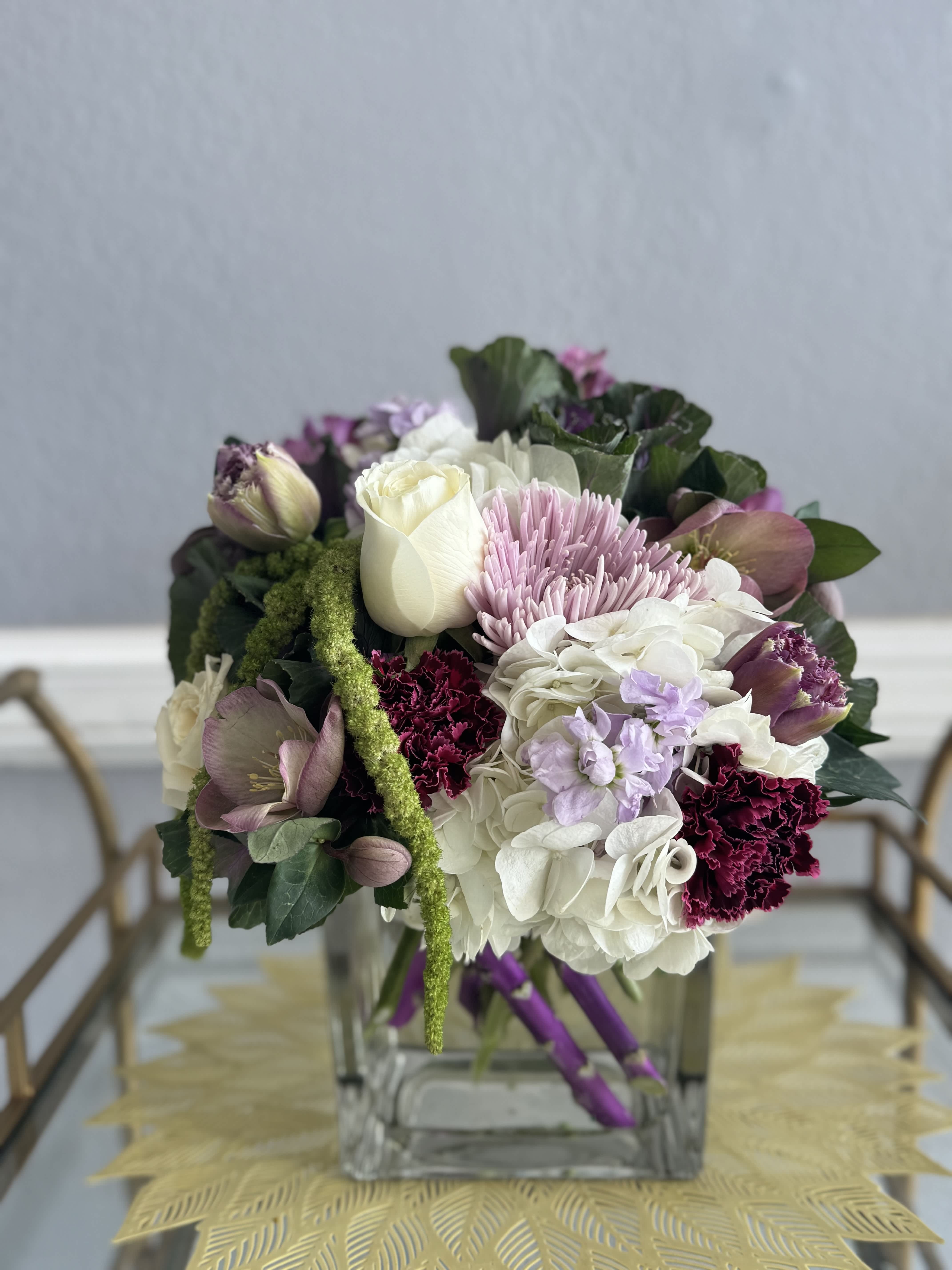 Mixed bouquet in a clear square vase with white, pink, and purple blooms