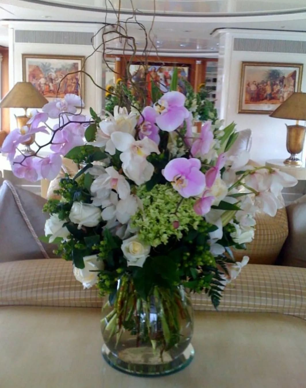 Large bouquet of pink and white orchids in a clear glass vase