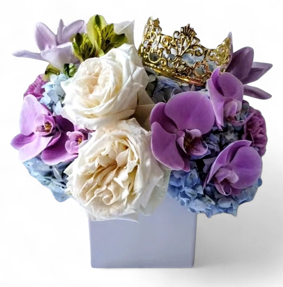 Violet Beauty Bouquet - Send this violet lavender bouquet today to make them smile with it's pretty blossoms of the day; roses orchids hydrangeas  and more arranged in a modern cube vase, adorned with a beautiful gold crown. Perfect for every reason to show them how much you care. 