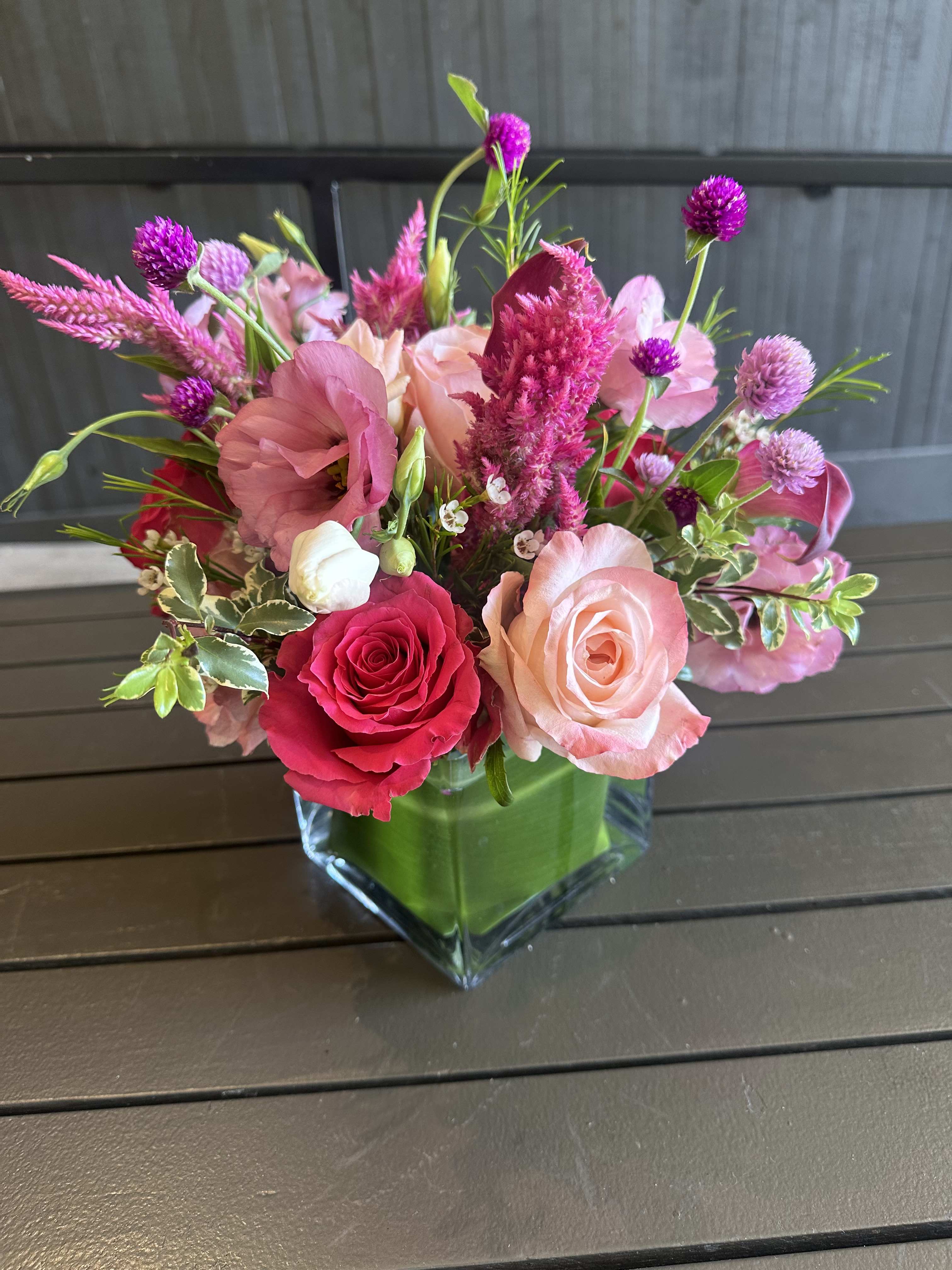 Summer Spritz - A beautiful mix of pink lisianthus, roses, calla lilies, wax flowers and summer foliage wrapped in tea leaves. 