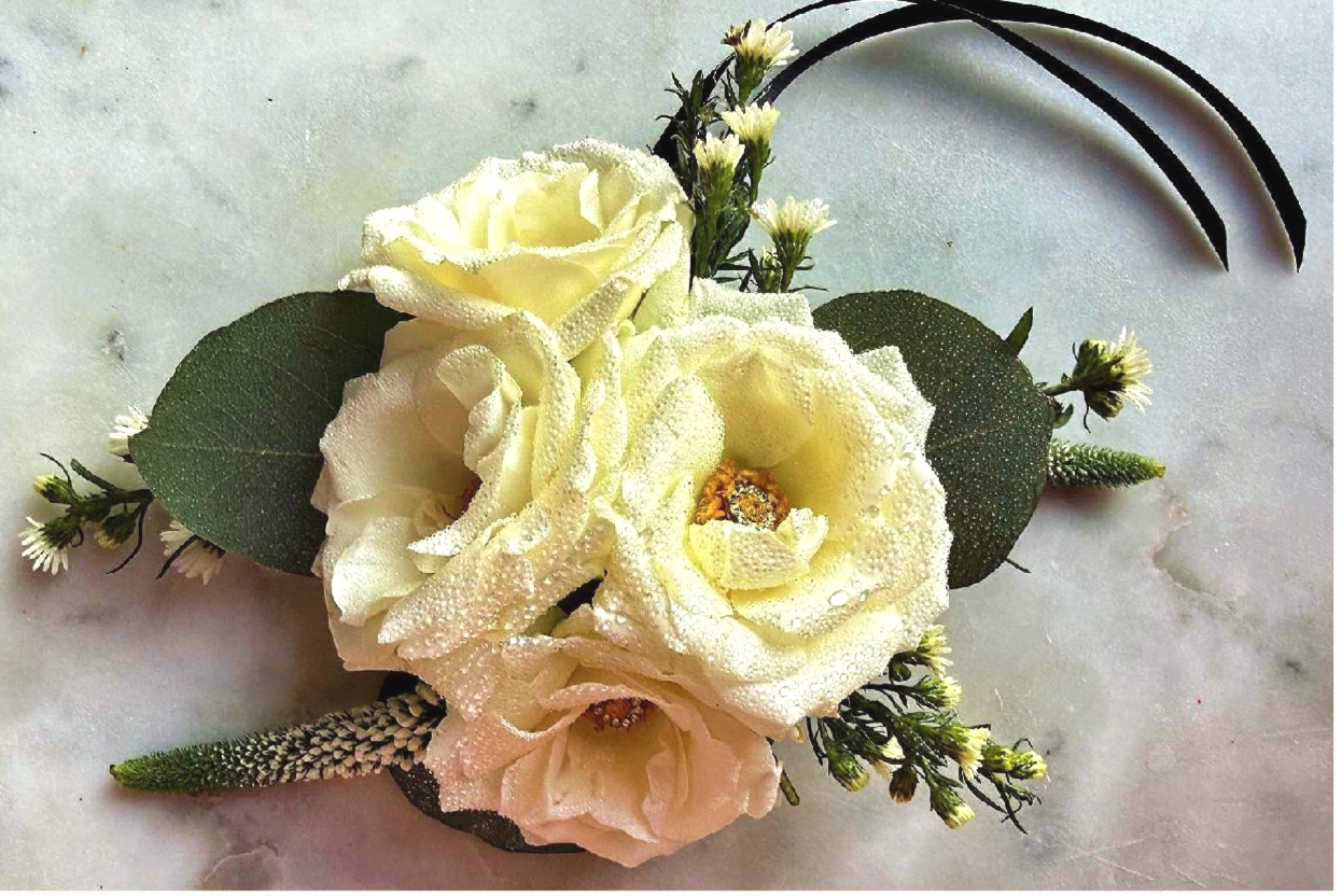  The Tuxedo Corsage by Evergreen Elegance  - A sophisticated monochromatic corsage featuring layers of tissue-thin White Spray Roses  and delicate Feverfew. Accented with textured Veronica and finished with a luxe black ribbon, this corsage is the perfect accessory for a modern formal look.
