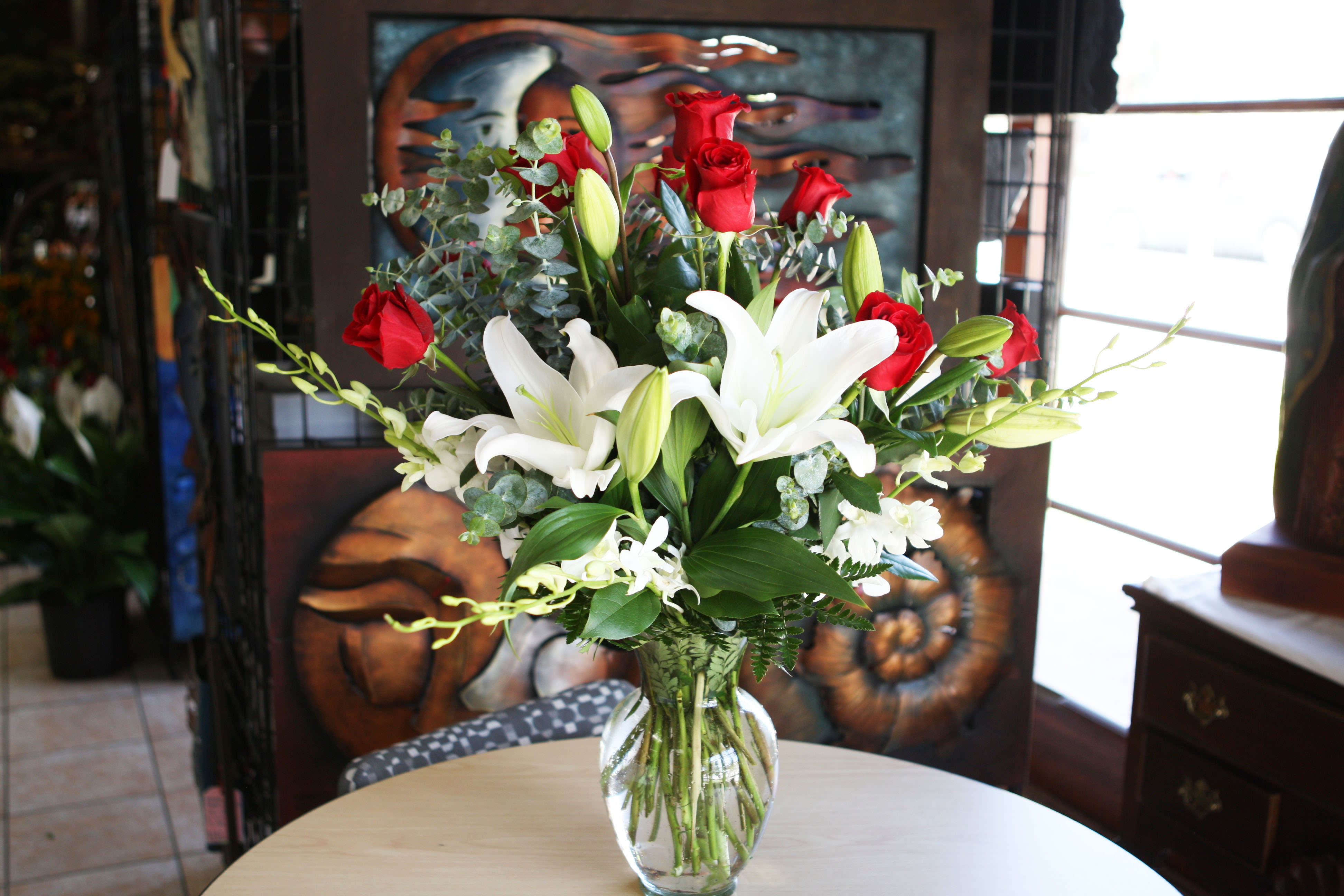 Red roses and white lilies in a clear glass vase