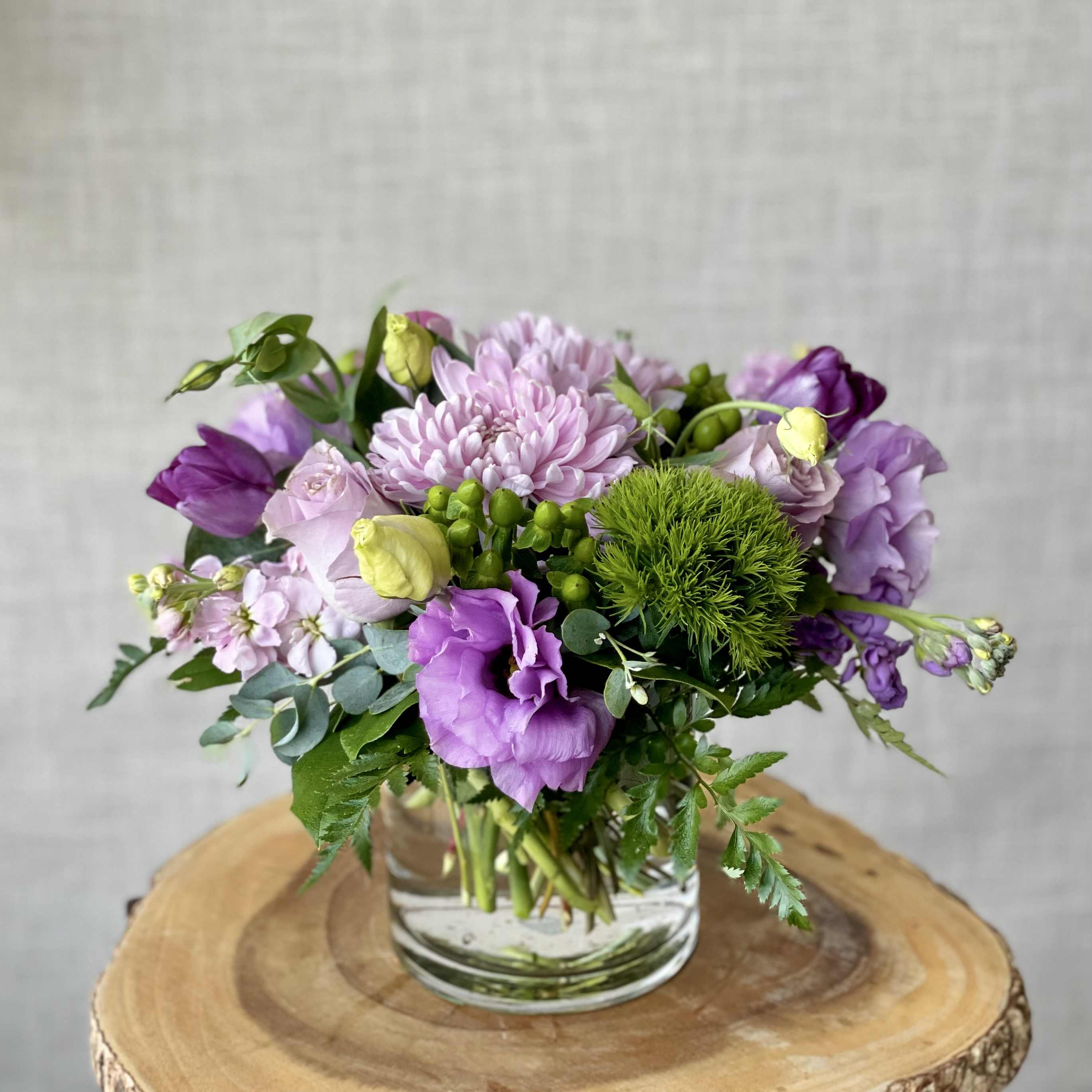 Purple and pink mixed bouquet in a clear glass vase