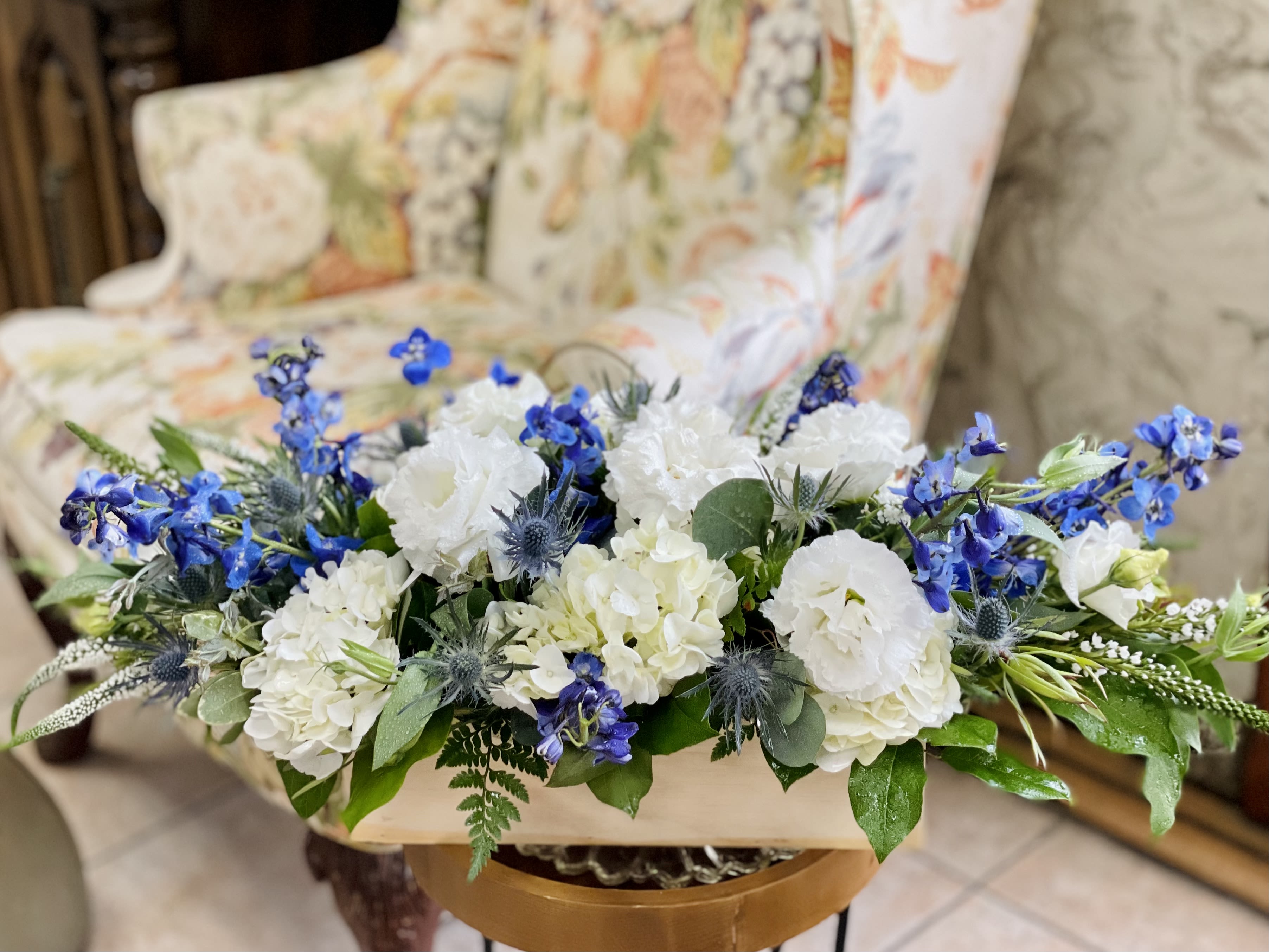 White and blue floral arrangement in a low container