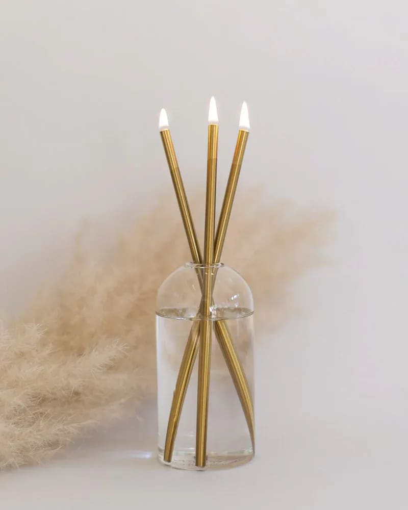 Clear glass vase with three gold reed diffusers