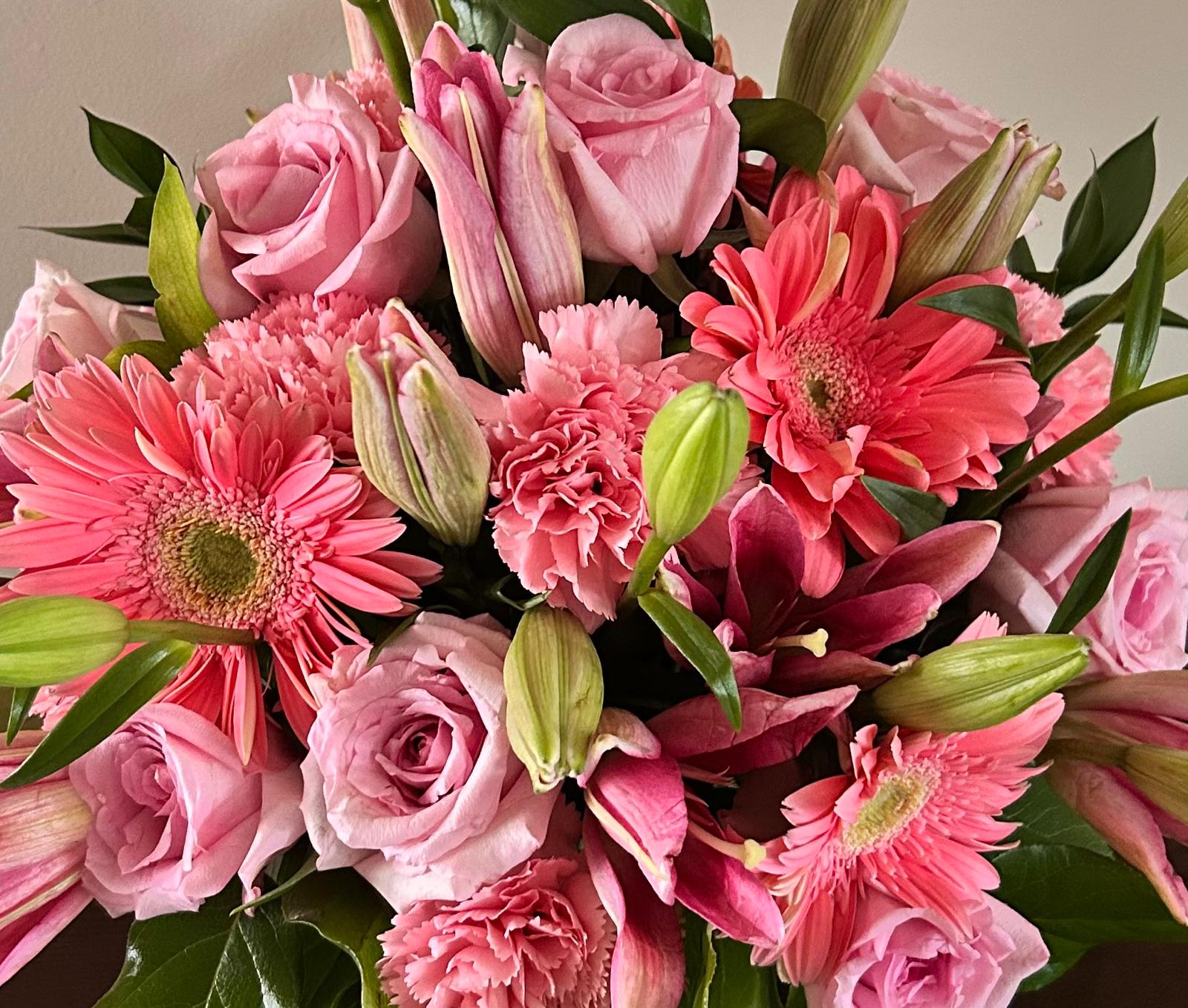 Pink roses, gerbera daisies, lilies, and carnations in a bouquet