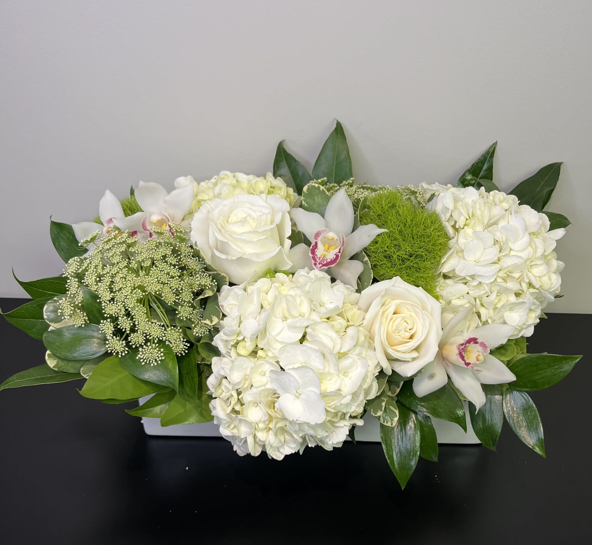 White Elegance by Chasing Petals - A monochromatic classic of white and green, with lots of texture in a white container, perfect for any occasion.