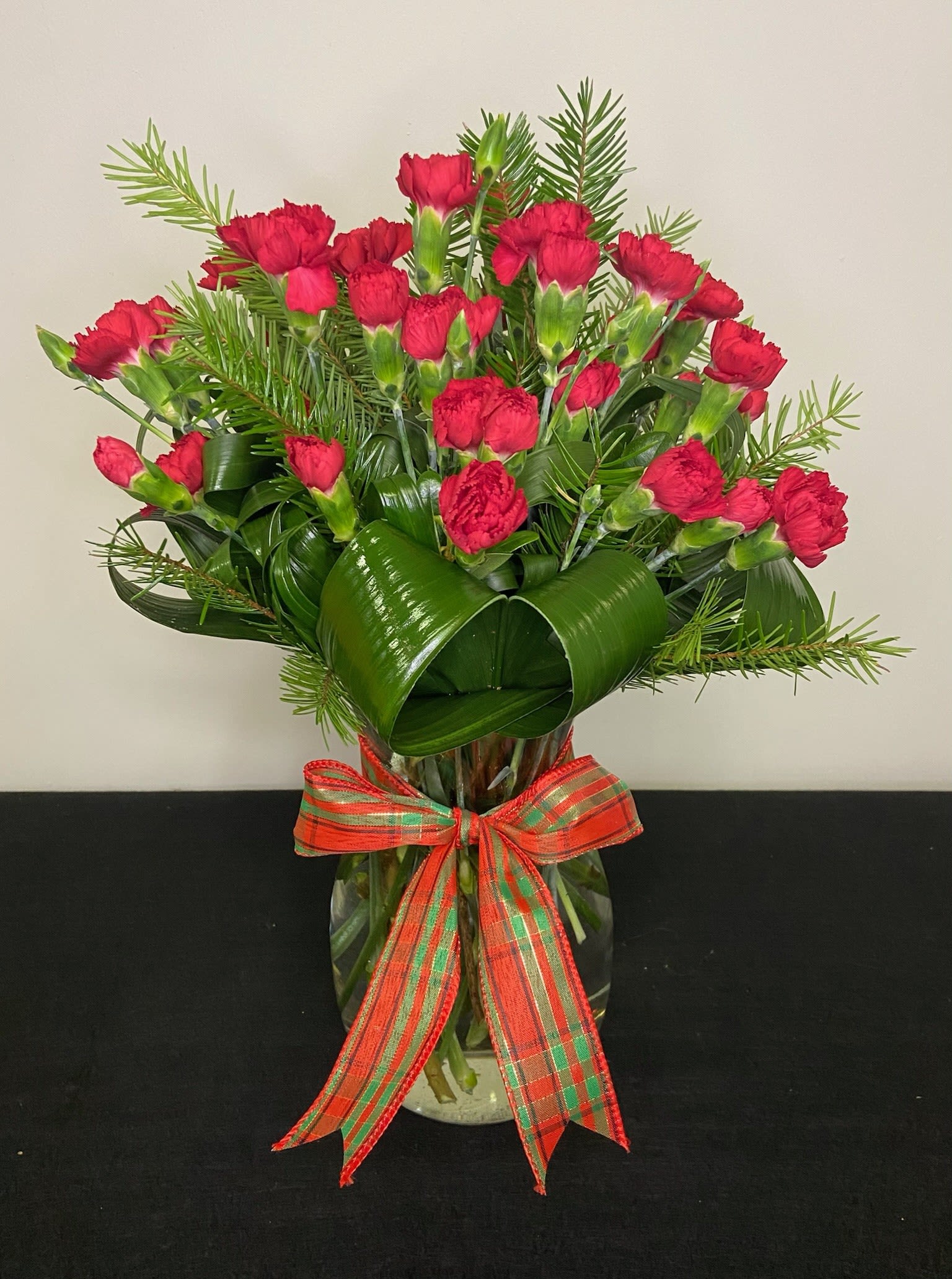 Christmas Everlasting by Chasing Petals - Rich and luscious red mini carnations surrounded by winter greenery, wrapped in a perfect Christmas bow.  Carnation colours and coordinating bow are adjustable. Please call us if you'd like to adjust colours.
