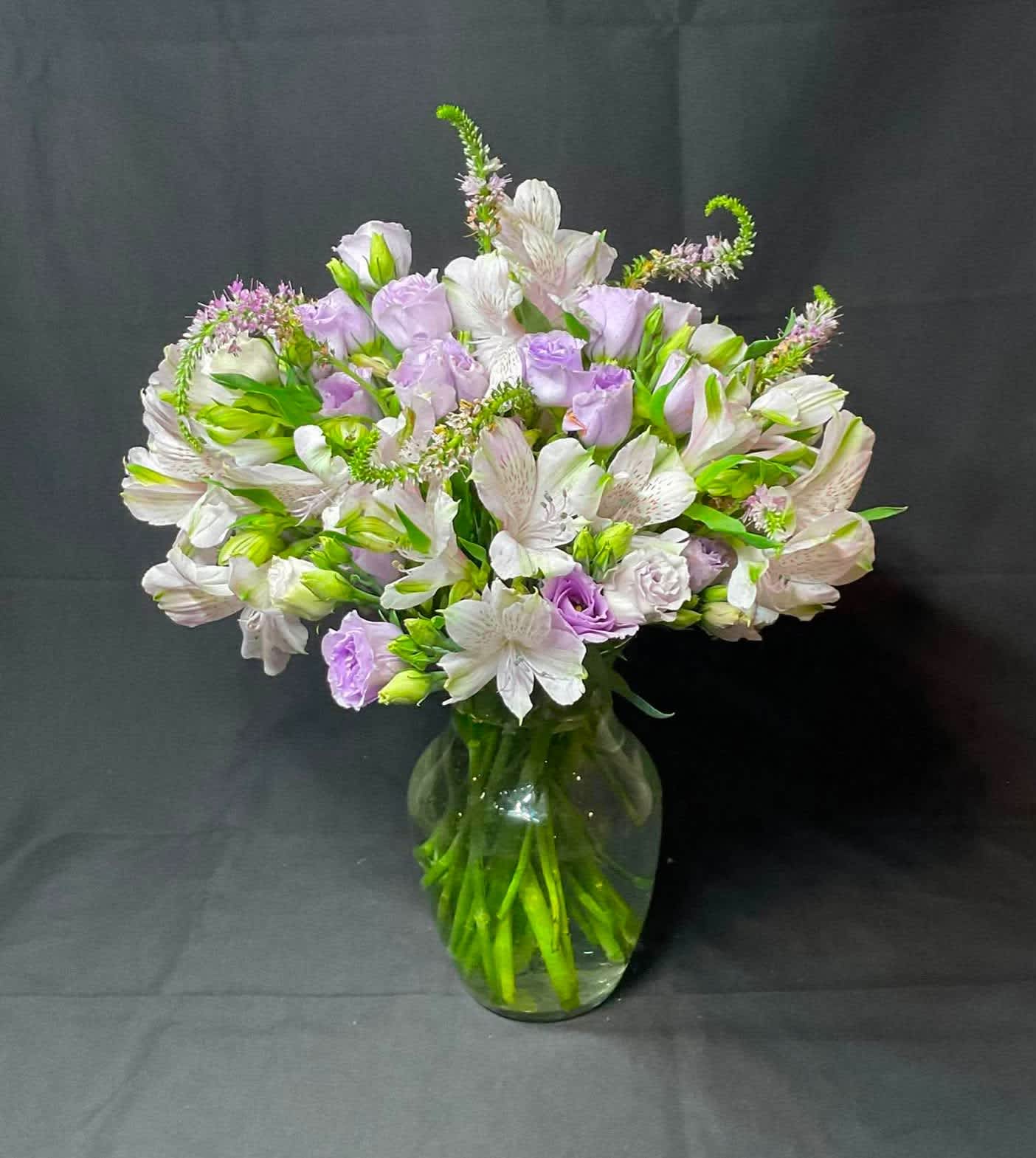 Lavender and white flowers arranged in a clear glass vase
