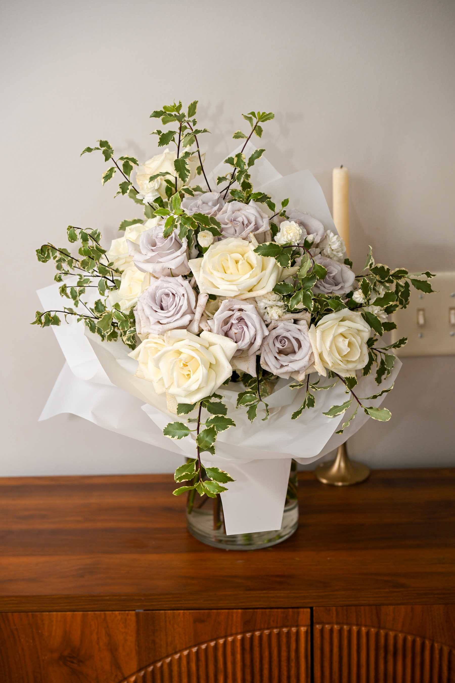 Bouquet of cream and pale lavender roses in white wrap