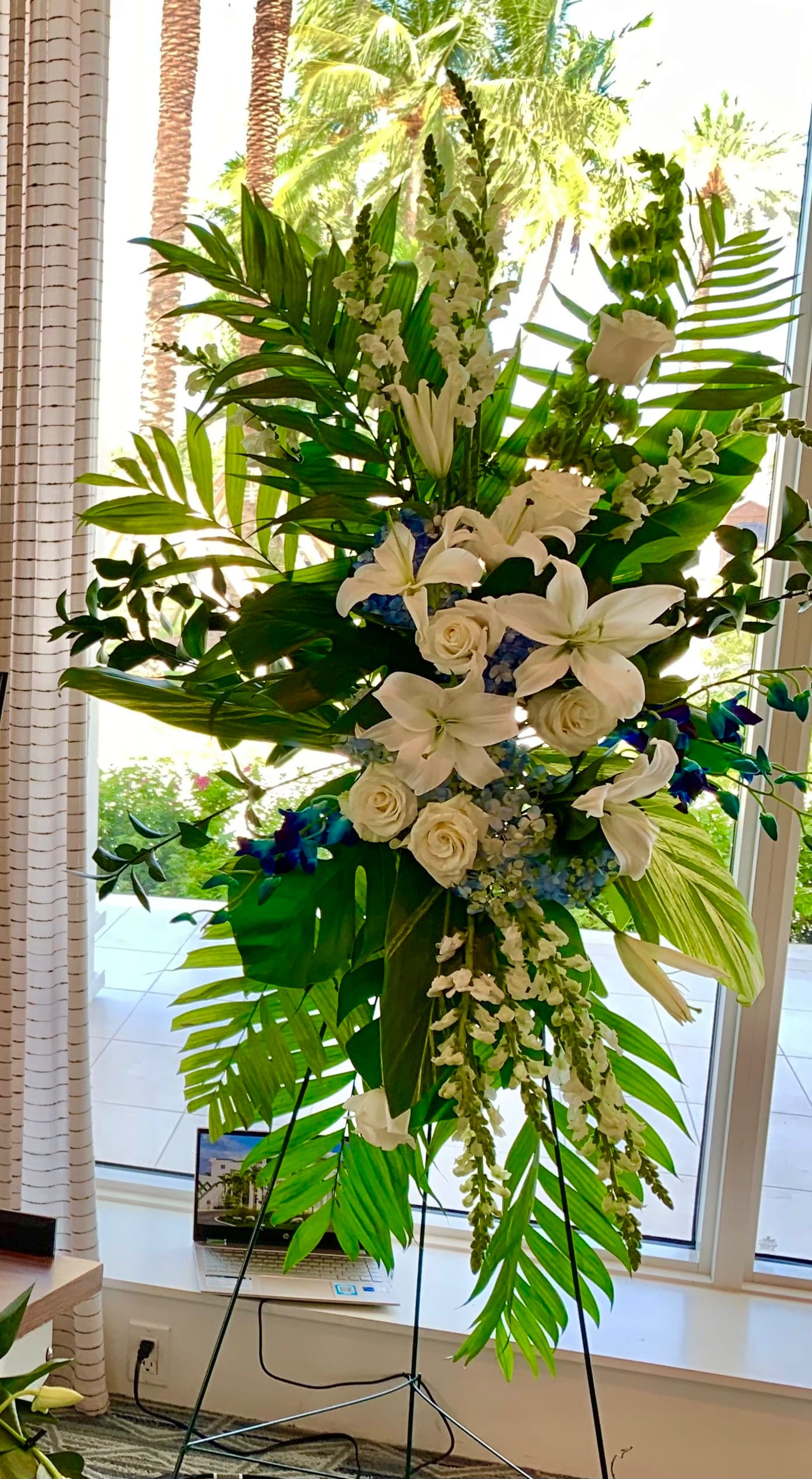 Tall white floral standing arrangement with lilies and roses
