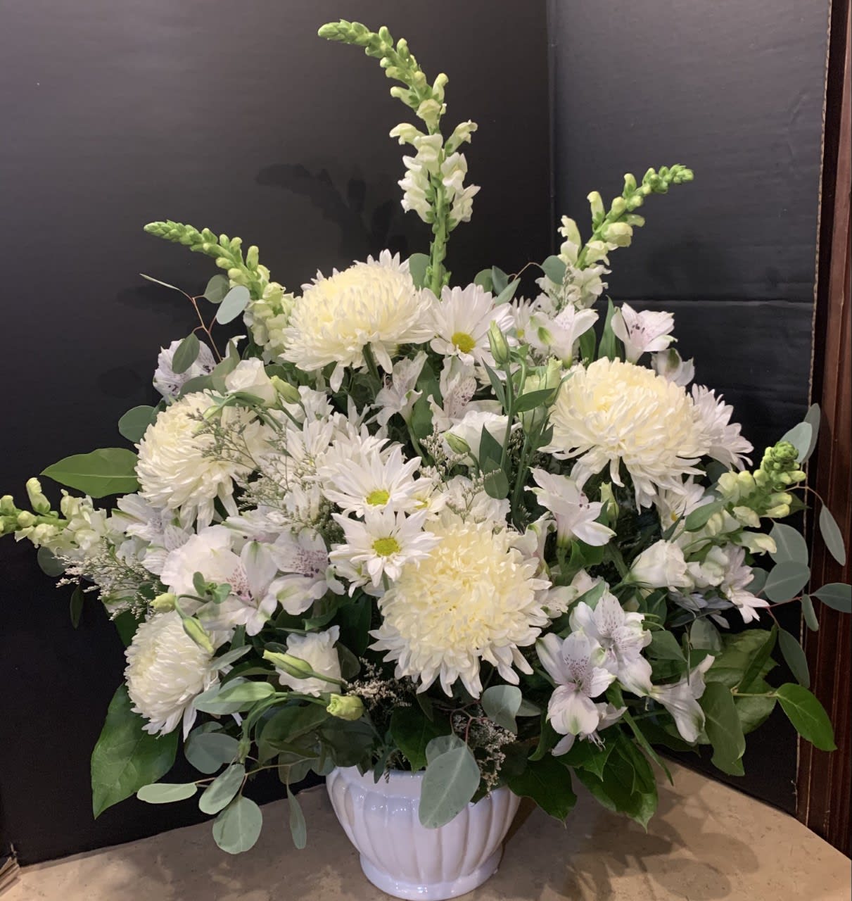White floral arrangement in a white ceramic vase