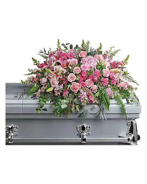 Beautiful Memories Casket Spray - "Like your beautiful memories, this dramatic spray of pink hydrangea, roses and lilies will take your breath away. A fresh, feminine symbol of hope for the service. This dramatic spray features pink hydrangea, pink roses, pink spray roses, pink stargazer lilies, pink carnations, pink larkspur, pink snapdragons, pink stock, green ivy, sword fern, silver dollar eucalyptus, seeded eucalyptus, and lemon leaf."