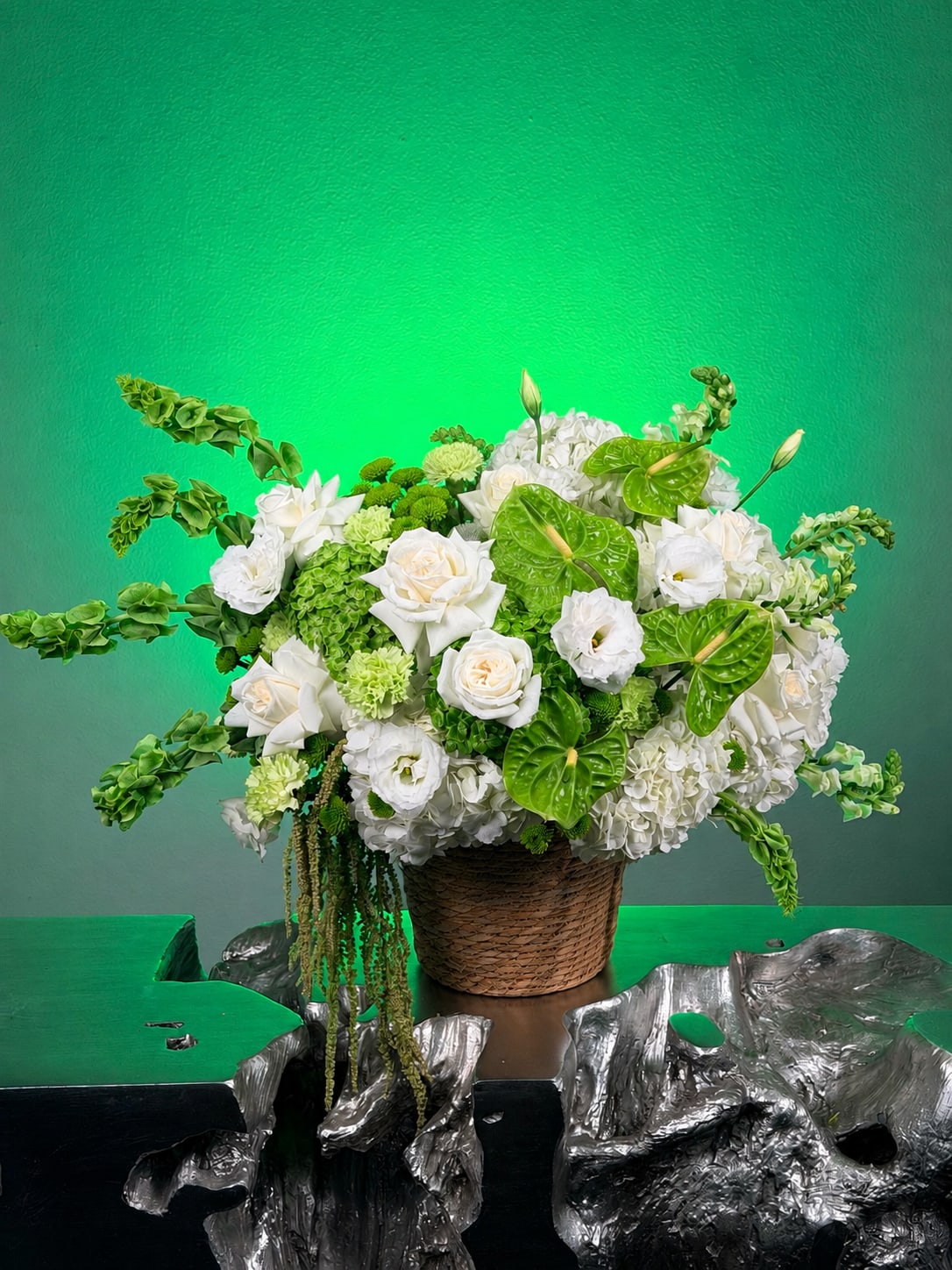 White and green floral arrangement in a woven basket