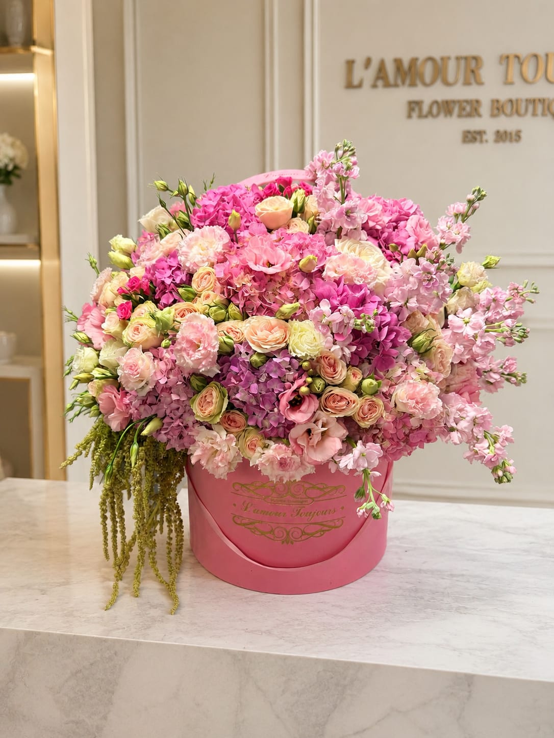 Large pink flower arrangement in a round pink box