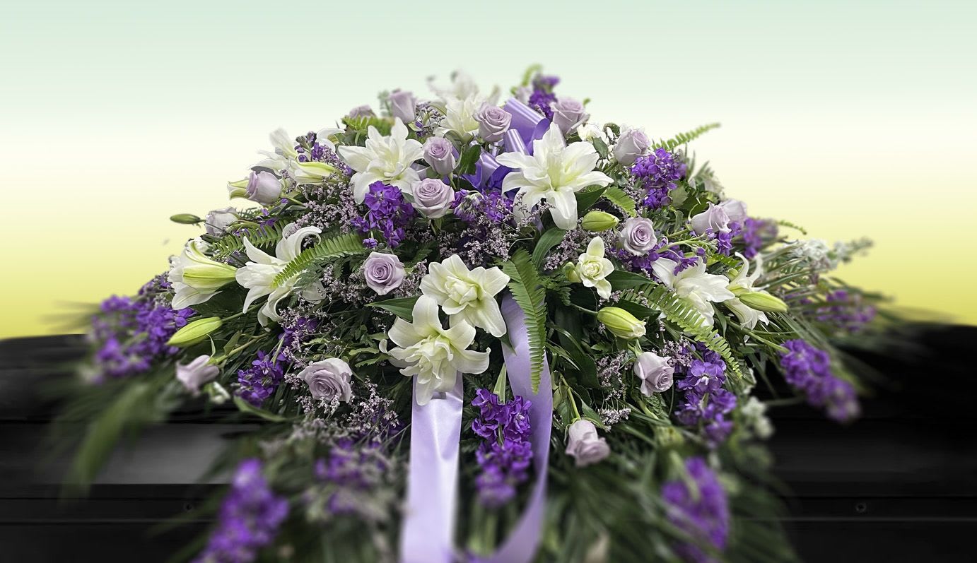 Welcome Home | Lavender - Celebrate a beautiful life with the breathtaking Welcome Home | Lavender arrangement. Artfully designed to command presence, this luxury tribute features a soft, comforting palette of premium lavenders, deep purples, and serene white blooms. Exquisitely framed by lush, sweeping palm fronds, this grand display offers a profound sense of peace, elegance, and warmth. Hand-arranged by our expert florists using the freshest seasonal blossoms, it serves as a stunning beacon of comfort and remembrance.  Looking to personalize this piece? We are happy to tailor the colors, flower selections, or size to match your vision perfectly. For custom requests or dedicated assistance, please call us directly at 305.769.3843.  Length 40" - 48" (101.6 x 121.92 cm)