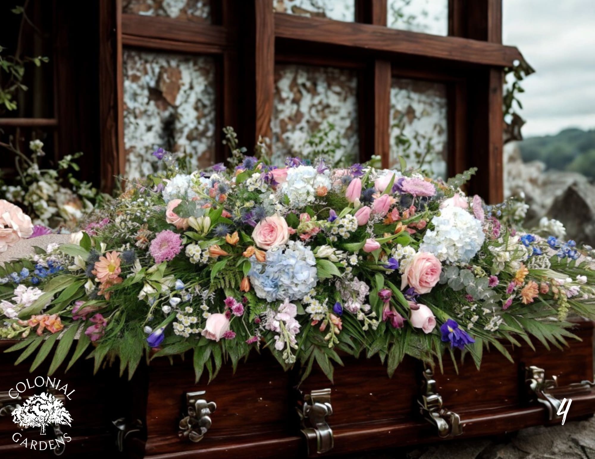 Large floral casket spray with pink, blue, and purple blooms