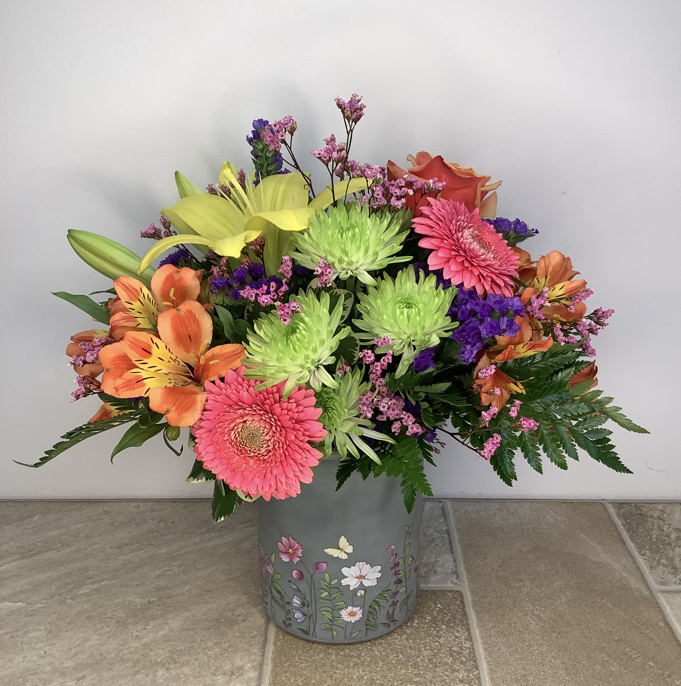 Colorful mixed bouquet in a floral tin container
