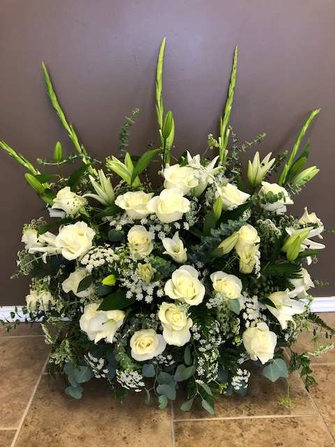 Large white floral arrangement with roses and lilies