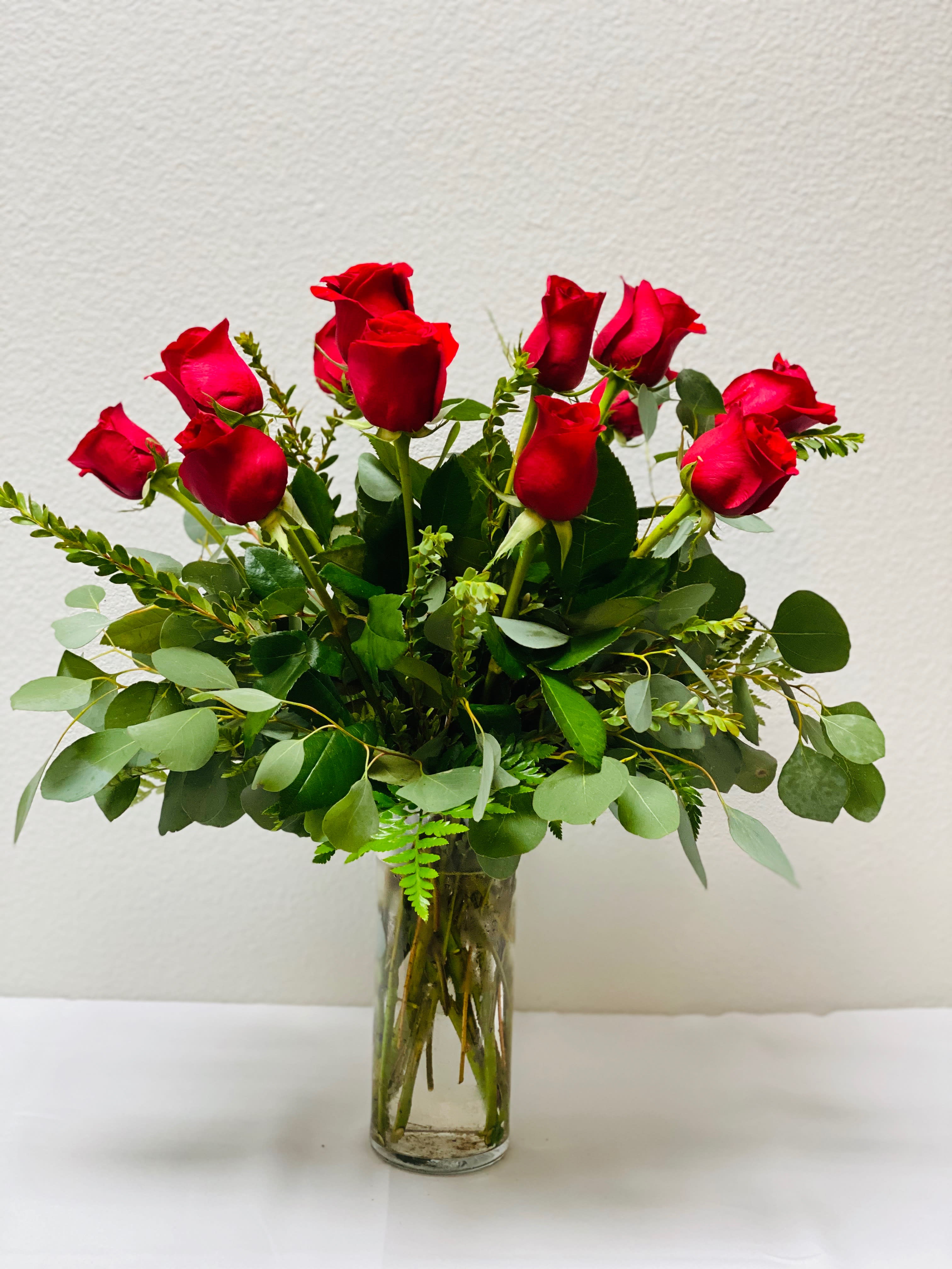 One dozen red roses - The Rose is the most universally loved flower. We offer a collection of long-stemmed roses classically presented and accented with seasonal foliage.