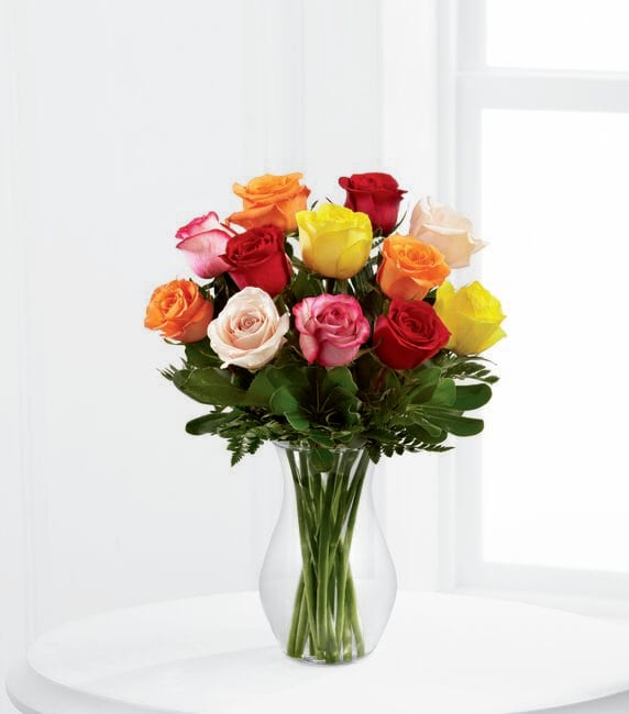 Mixed-color roses arranged in a clear glass vase