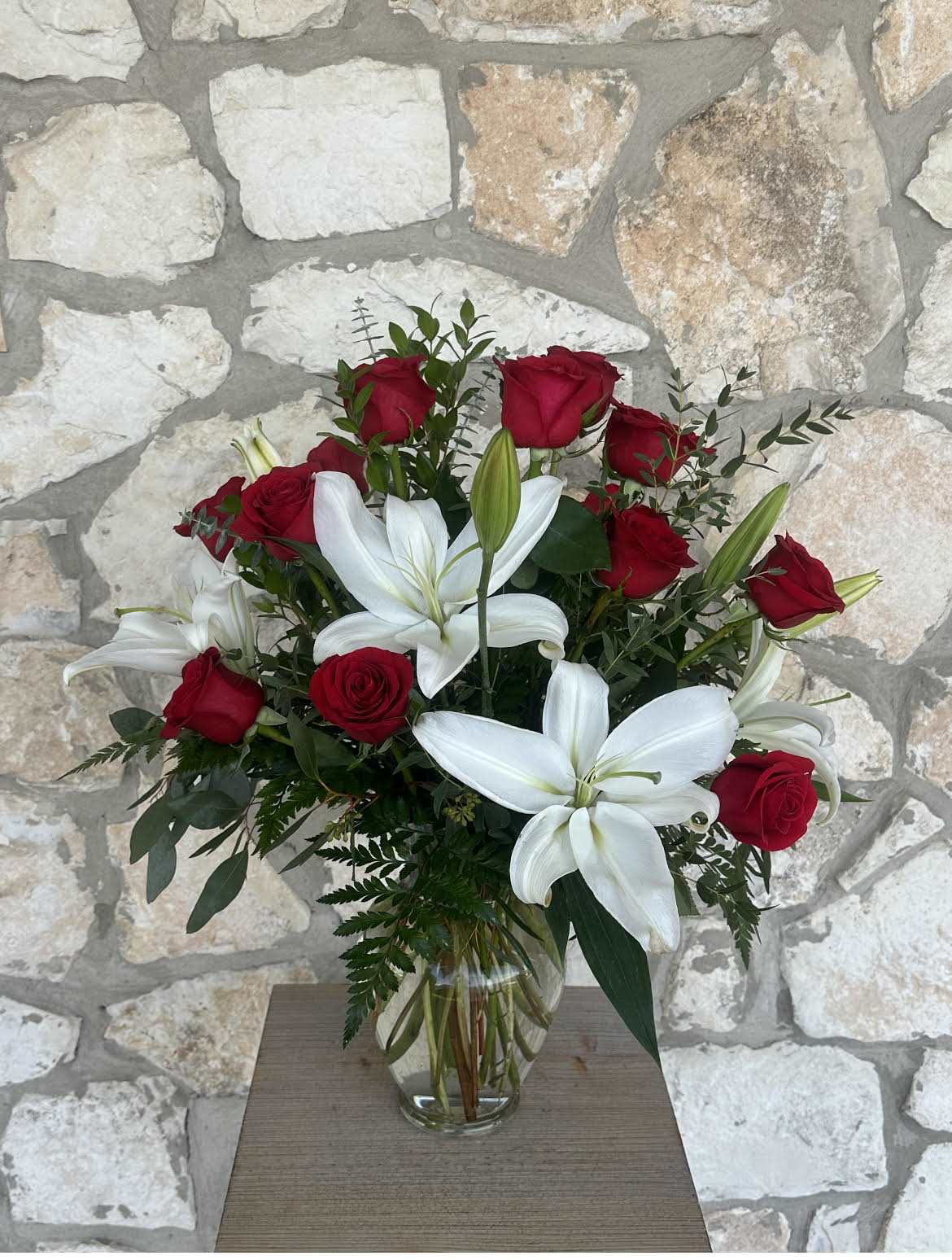 Red roses and white lilies in a clear glass vase