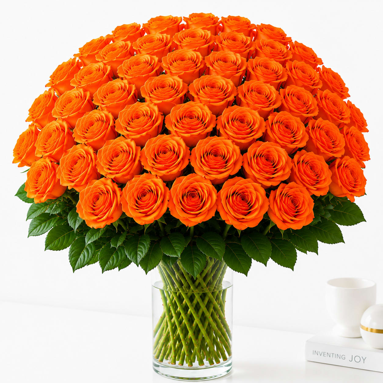 Large bouquet of orange roses in a clear glass vase