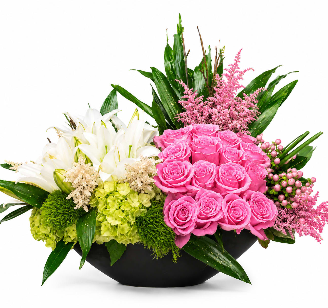 Pink roses and white lilies in a black bowl vase with green hydrangeas