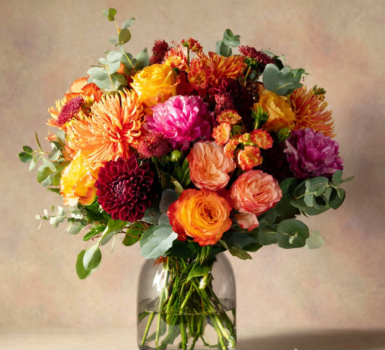 Colorful mixed bouquet of roses and chrysanthemums in a glass vase