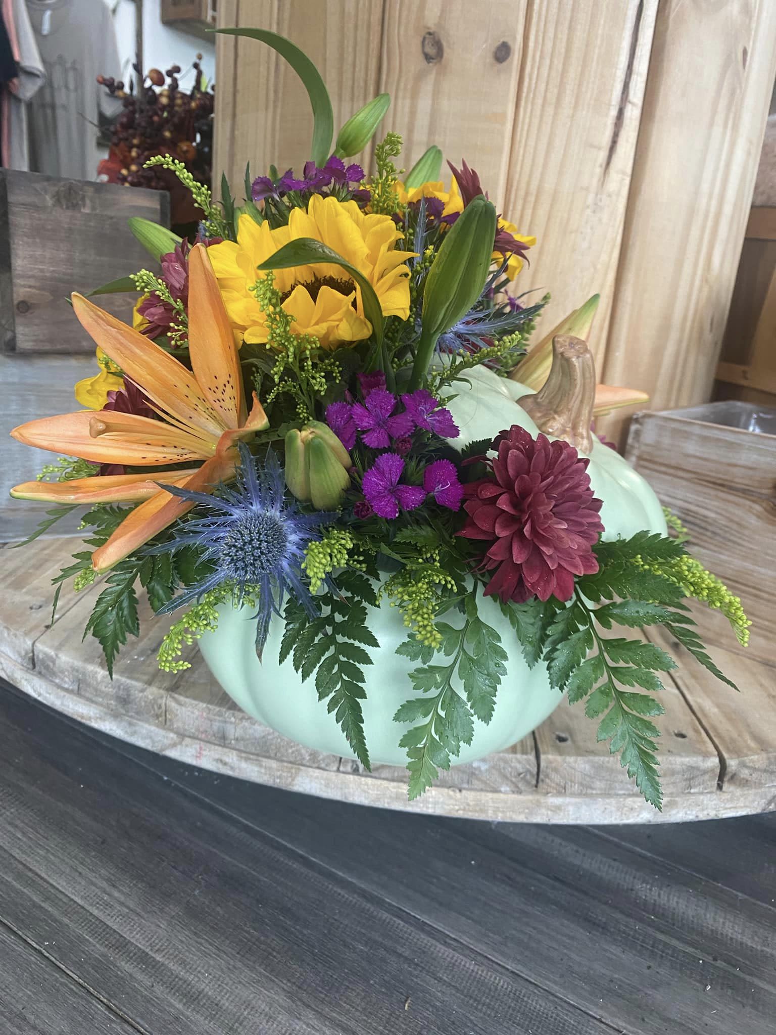 Mixed bouquet in a mint pumpkin-shaped container with sunflowers and lilies