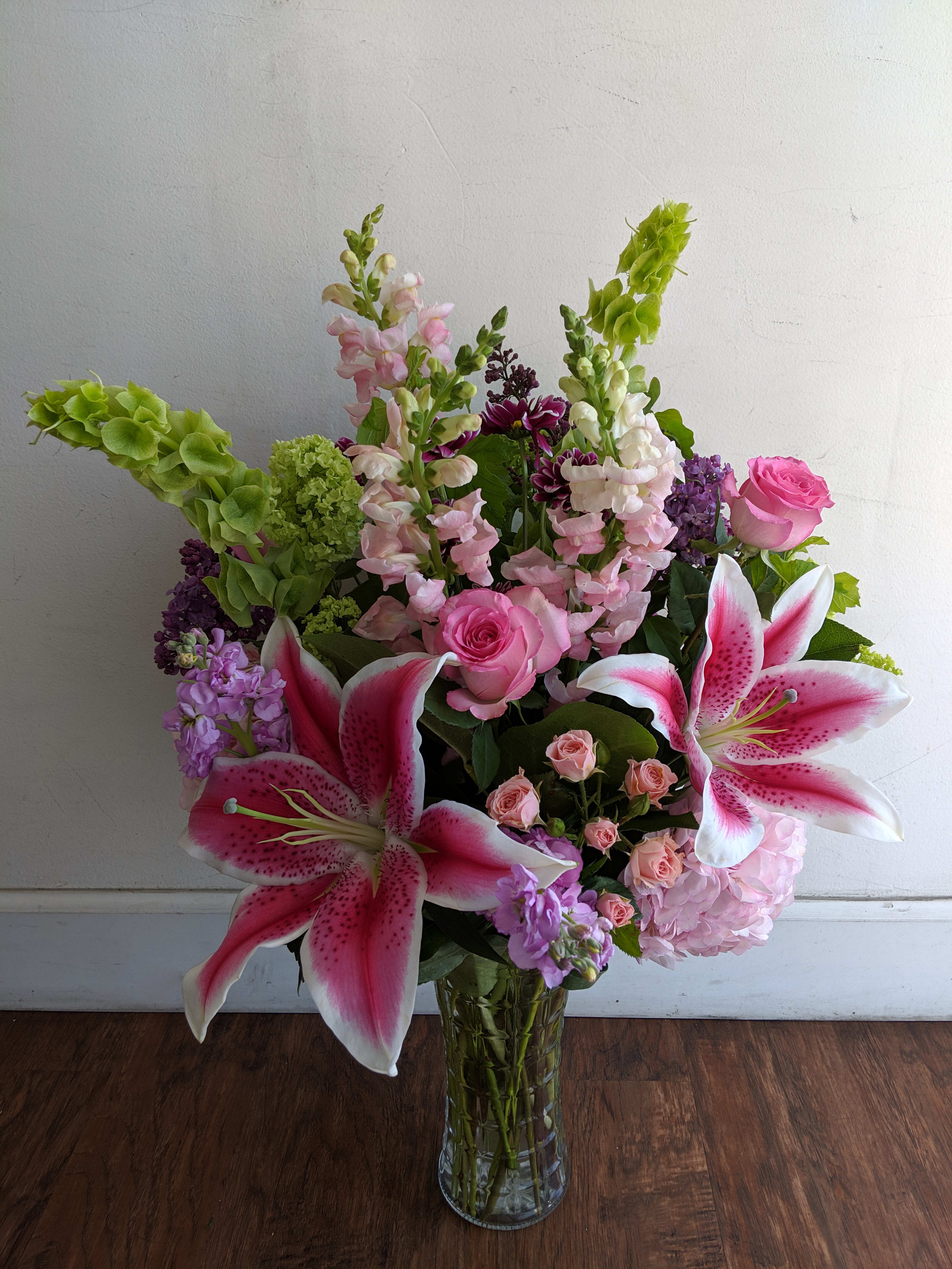 Pink lilies and roses in a clear glass vase