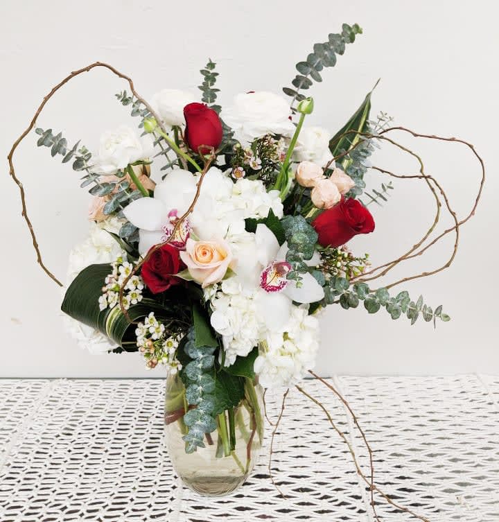 Bouquet of red and white flowers in a clear glass vase