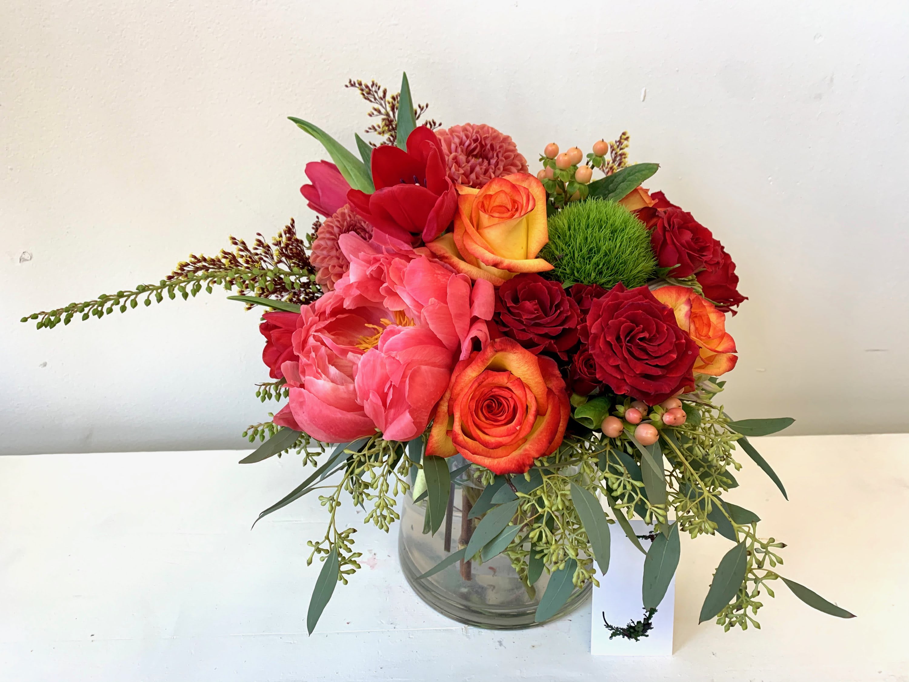 Red and pink floral arrangement in a glass vase